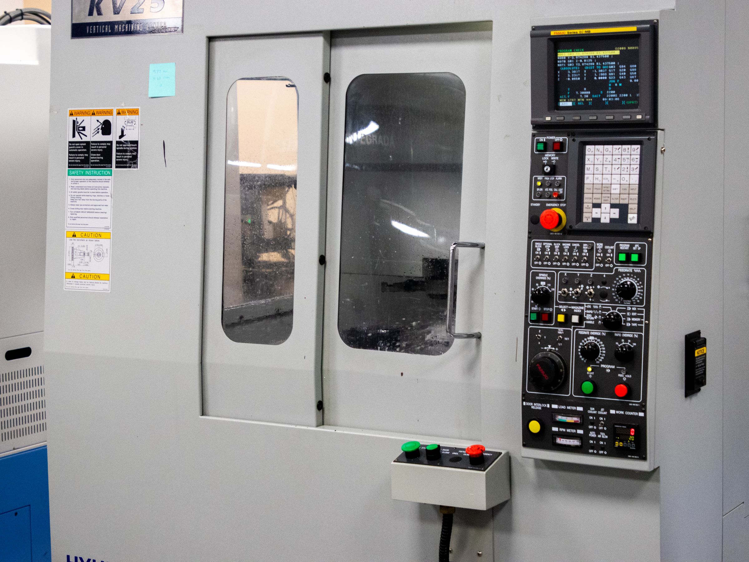 A digital control panel beside industrial machinery